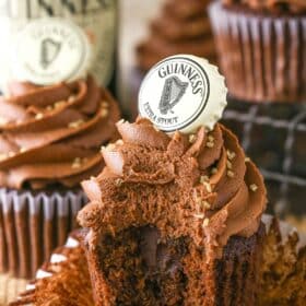 A Guinness chocolate cupcake with a bite out of it.