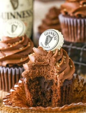 A Guinness chocolate cupcake with a bite out of it.
