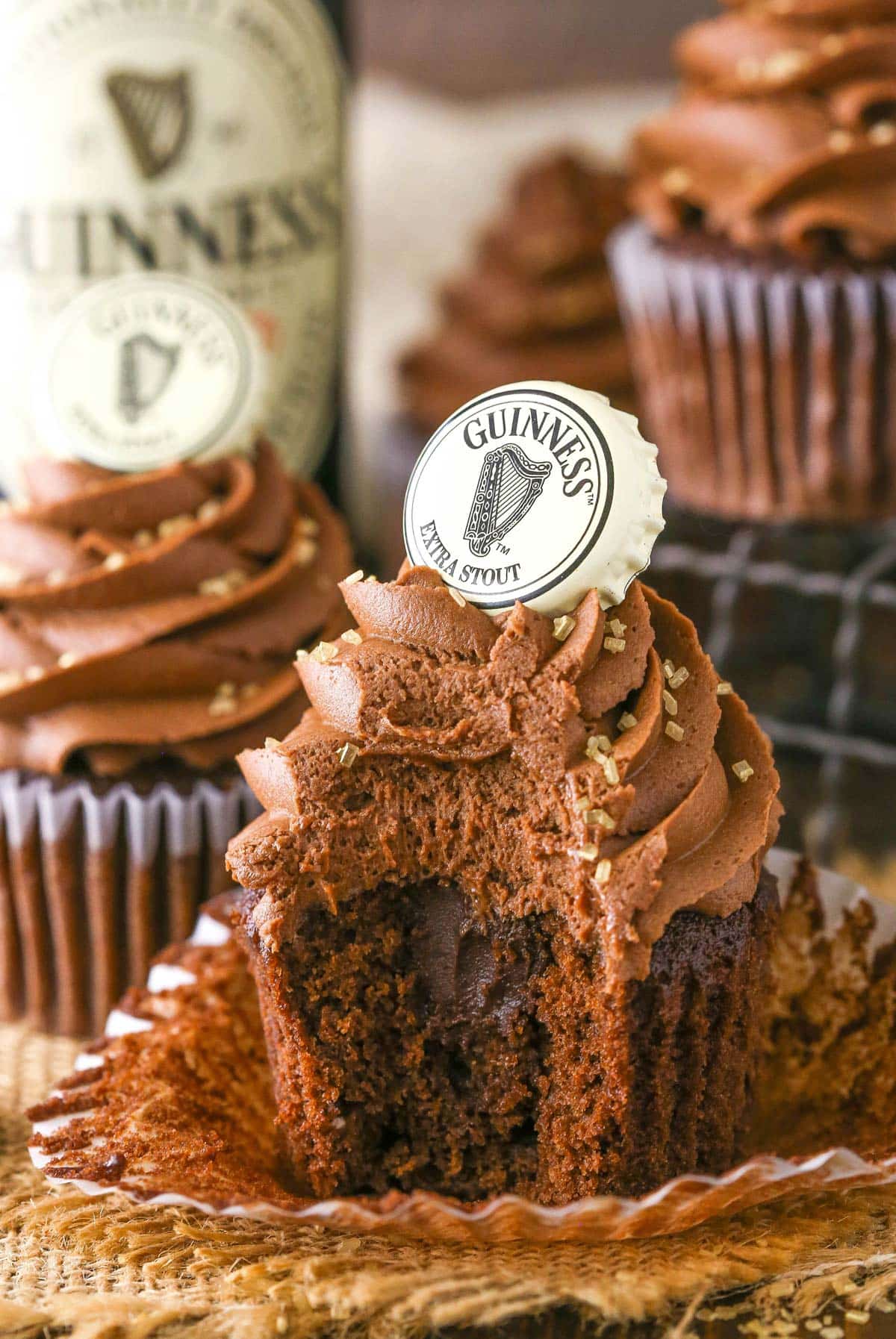 A Guinness chocolate cupcake with a bite out of it.