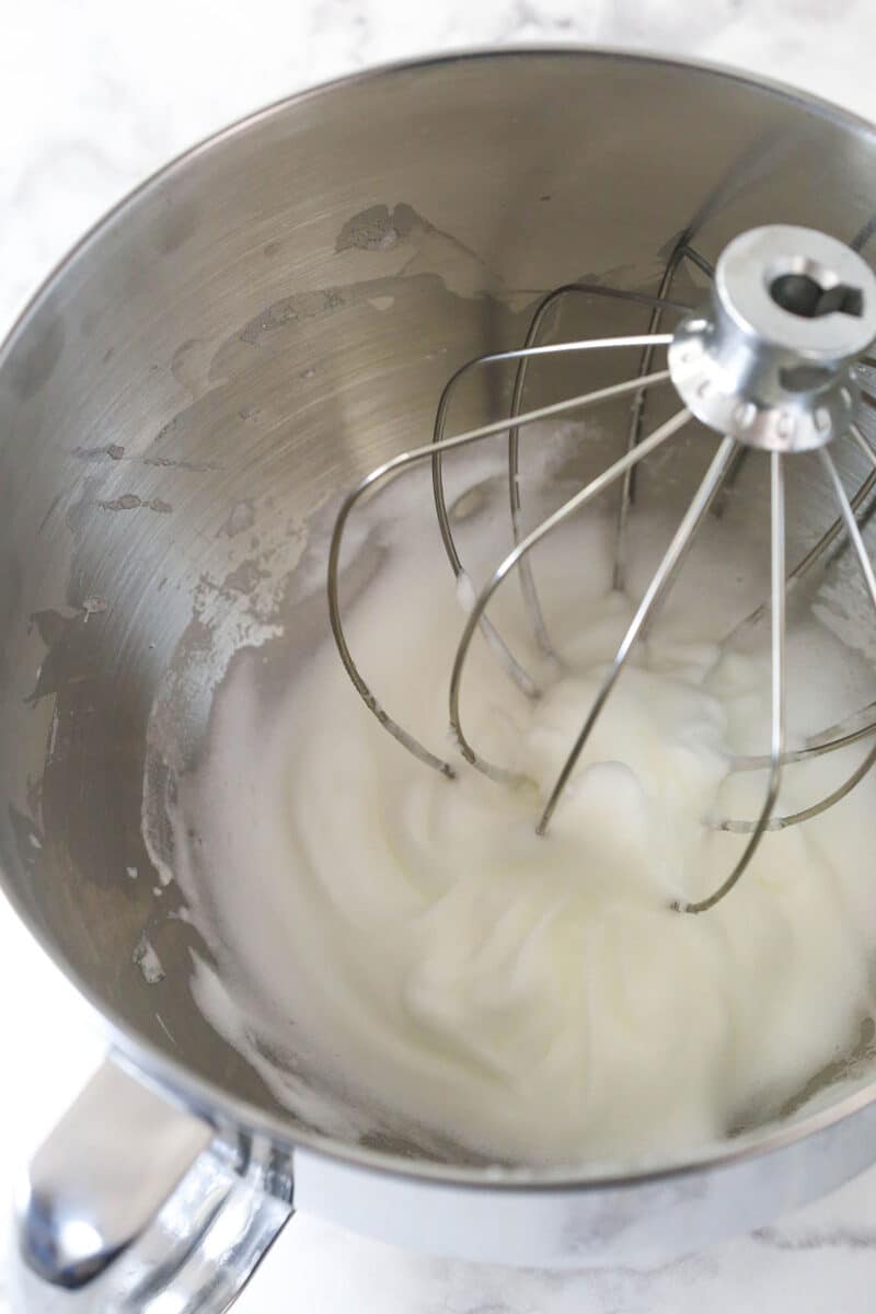 Beating egg whites until stiff peaks form.