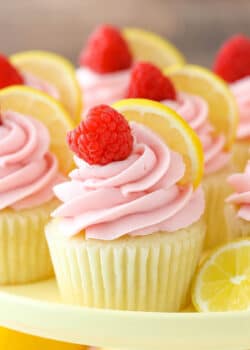 Close up of a lemon raspberry cupcake on a yellow cake plate.