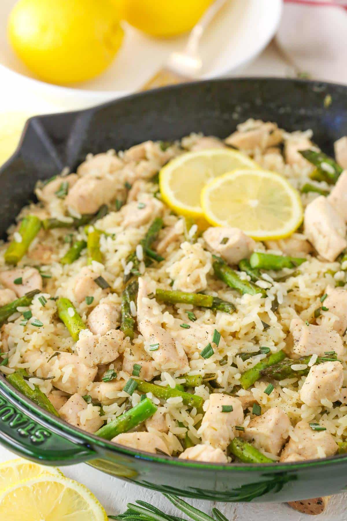 Lemon rosemary chicken and rice in a dark green skillet.