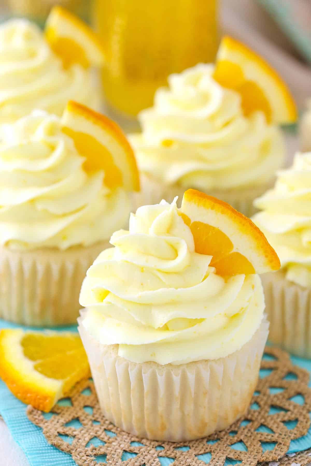 Close up of a mimosa cupcake with more cupcakes in the background.