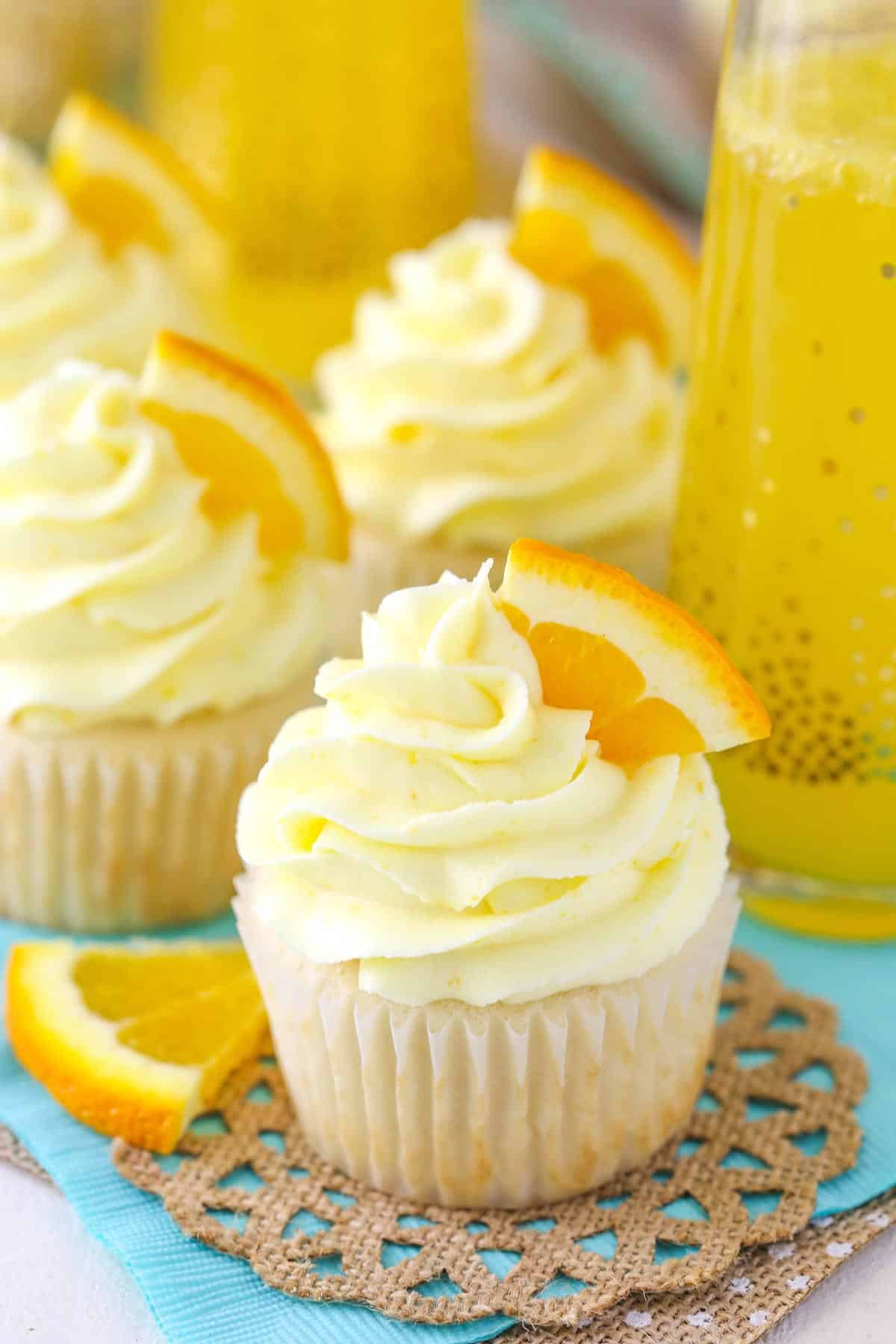 Close up of a mimosa cupcake with more cupcakes in the background.