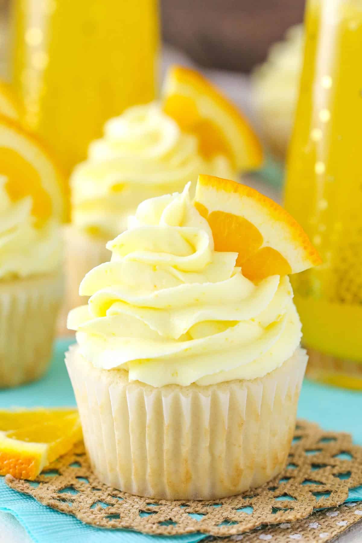 A mimosa cupcake on teal and burlap napkins.