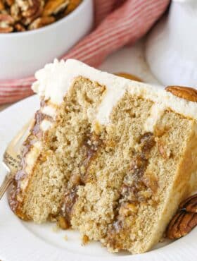 A slice of pecan pie layer cake on a white plate.