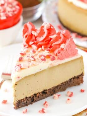 A slice of peppermint espresso brownie cheesecake on a white plate.