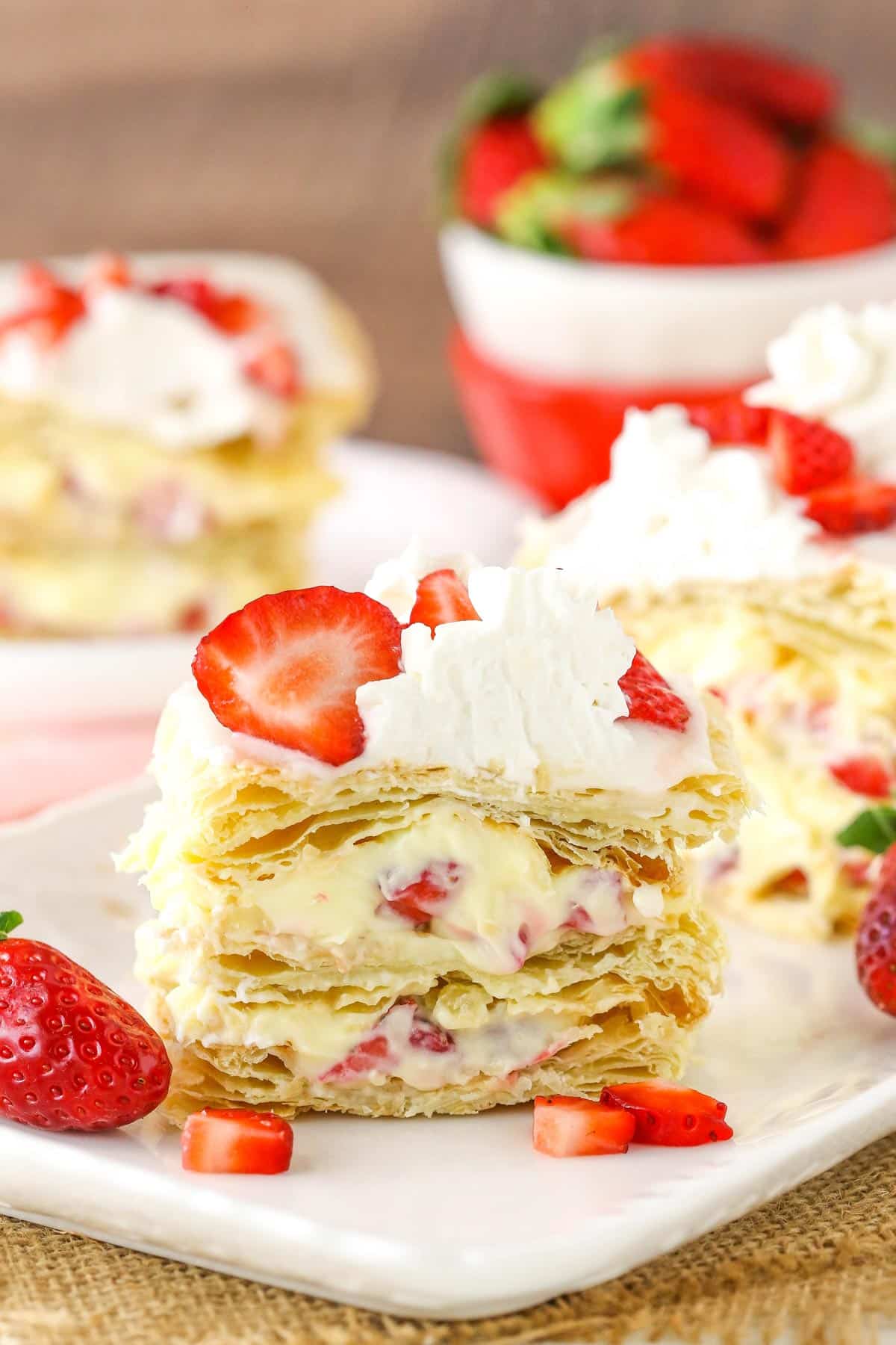 A slice of Strawberry Napoleon on a white serving tray.