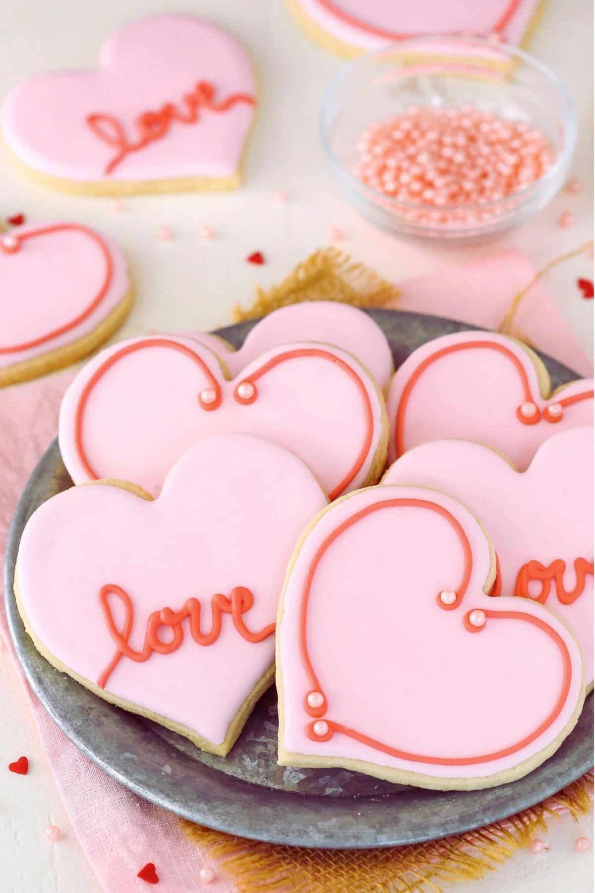 Heart-shaped cutout cookies on a metal plate.