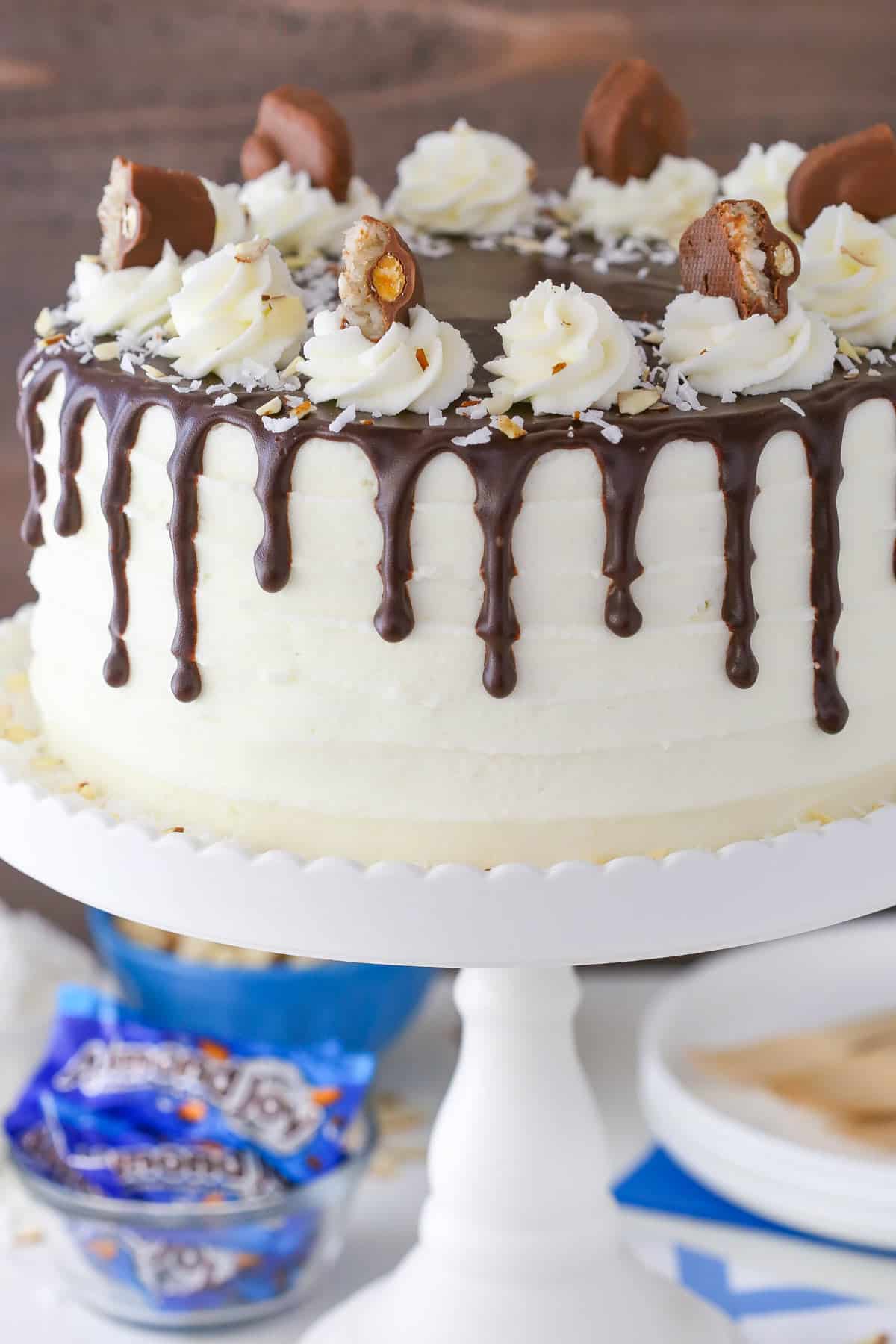 An almond joy layer cake on a white cake plate.