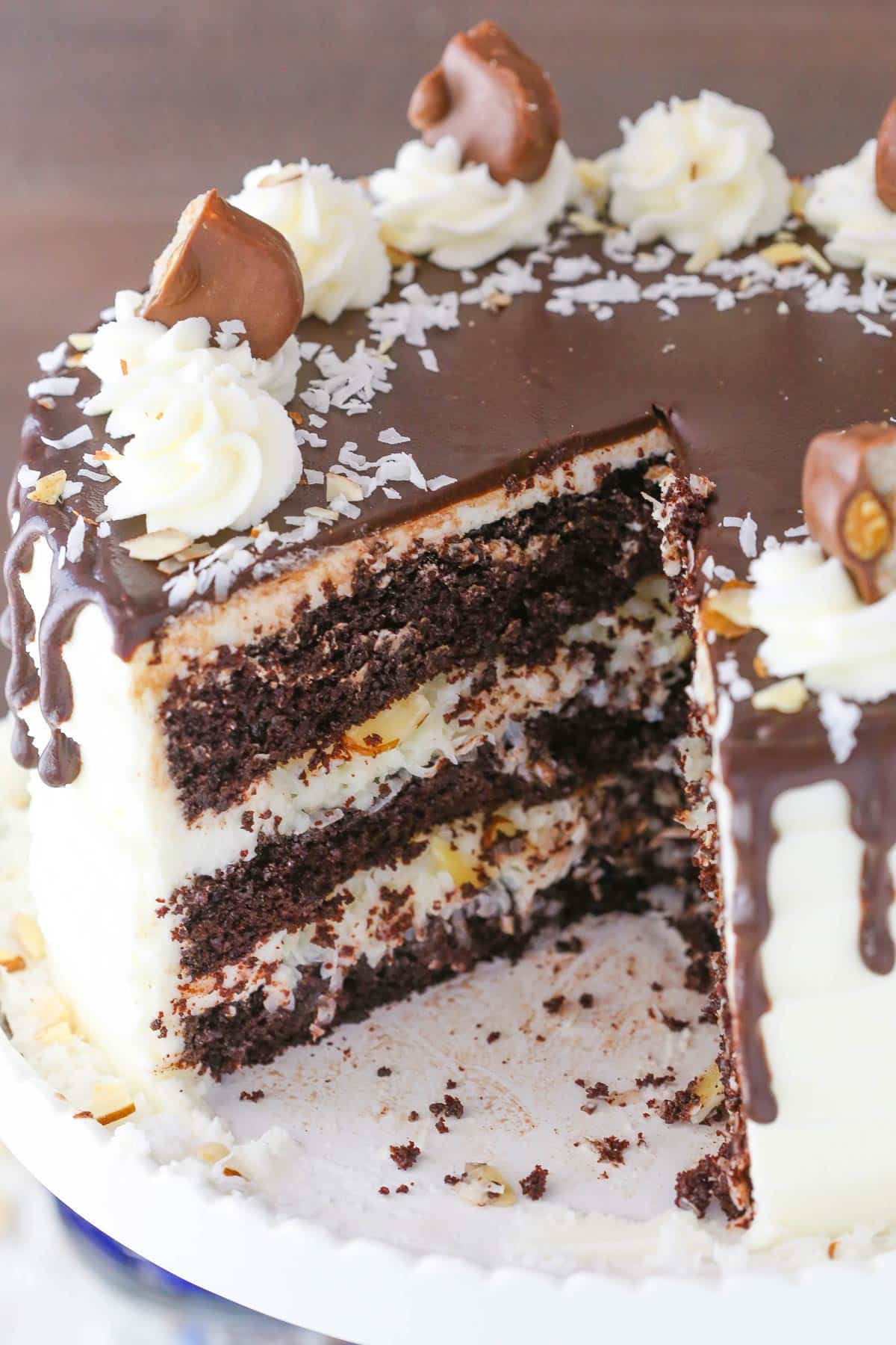 An almond joy layer cake with a slice removed to show inside layers.
