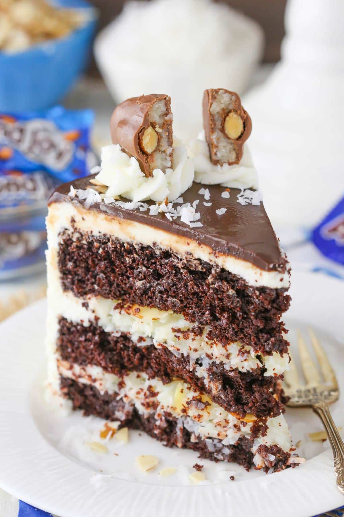 A slice of almond joy layer cake on a white plate.