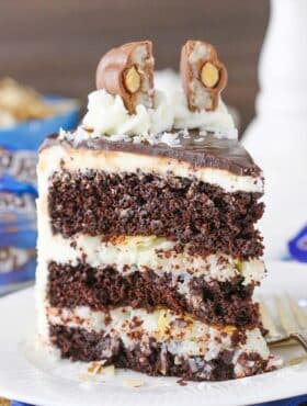 A slice of almond joy layer cake on a small white plate.