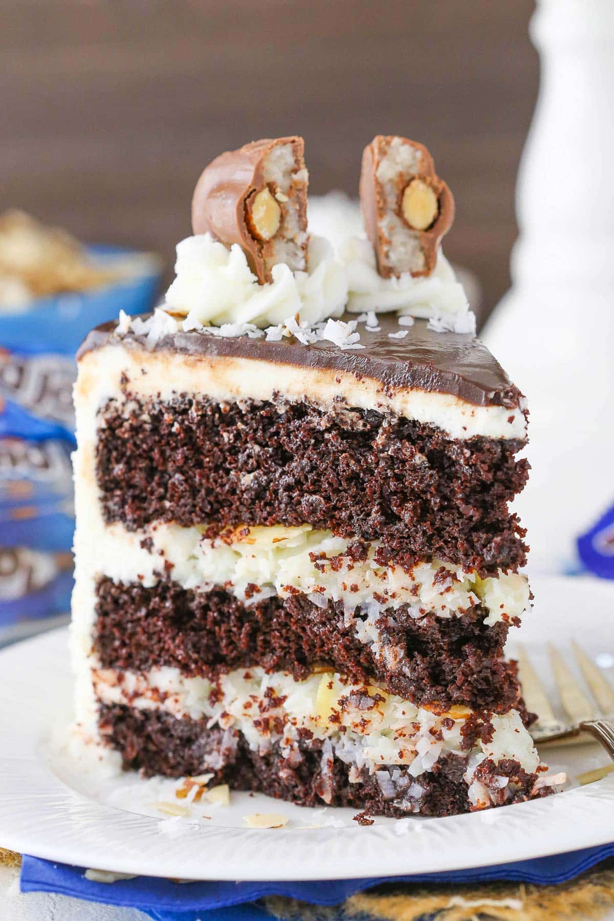 A slice of almond joy layer cake on a small white plate.