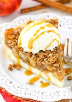 A slice of apple crumb cheesecake pie with ice cream and caramel on top.