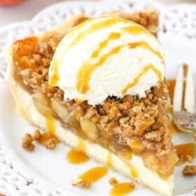 A slice of apple crumb cheesecake pie with ice cream and caramel on top.