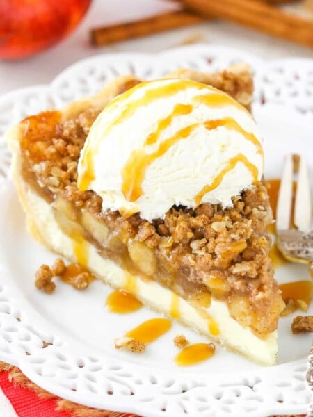 A slice of apple crumb cheesecake pie with ice cream and caramel on top.