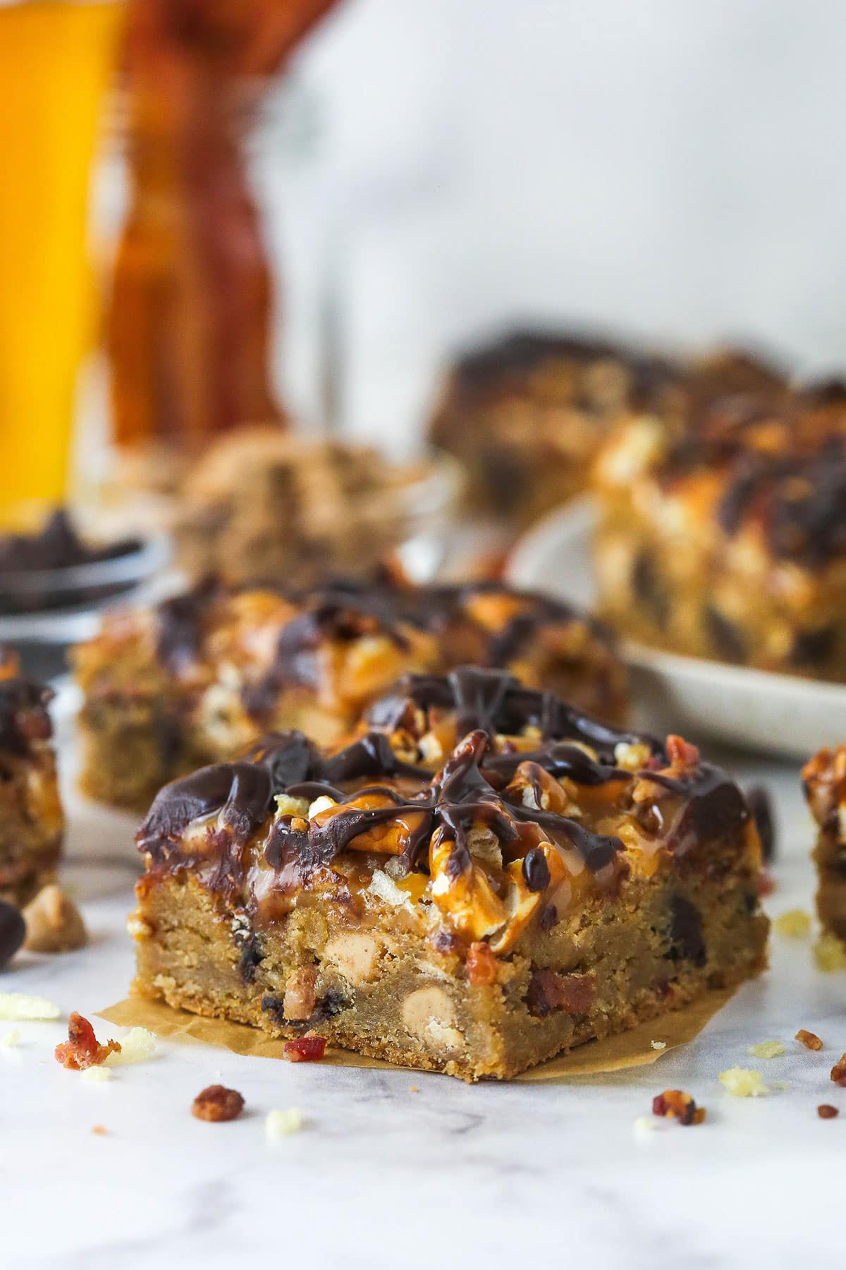 one cookie bar on brown parchment paper in foreground with other bars blurred in the background