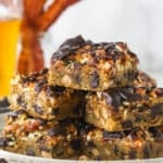 cookie bars piled onto speckled plate with bacon and beer in background
