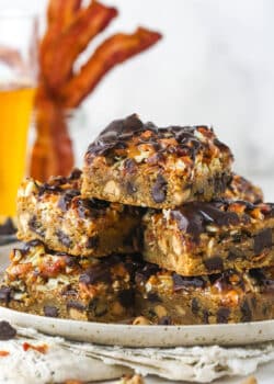 cookie bars piled onto speckled plate with bacon and beer in background