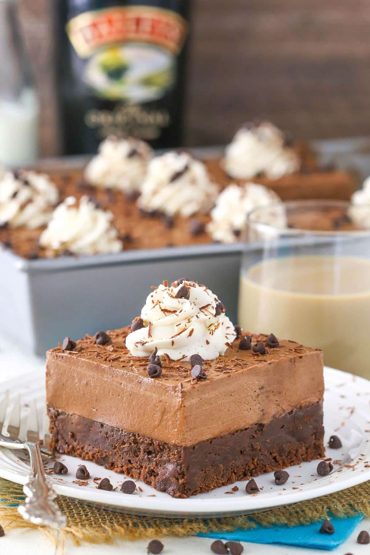 A slice of baileys chocolate mousse brownie cake on a small white plate.