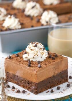 A slice of baileys chocolate mousse brownie cake on a small white plate.