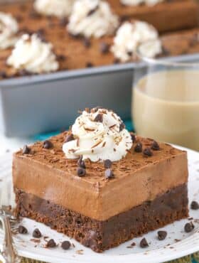 A slice of baileys chocolate mousse brownie cake on a small white plate.
