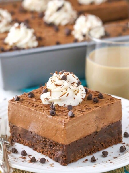 A slice of baileys chocolate mousse brownie cake on a small white plate.