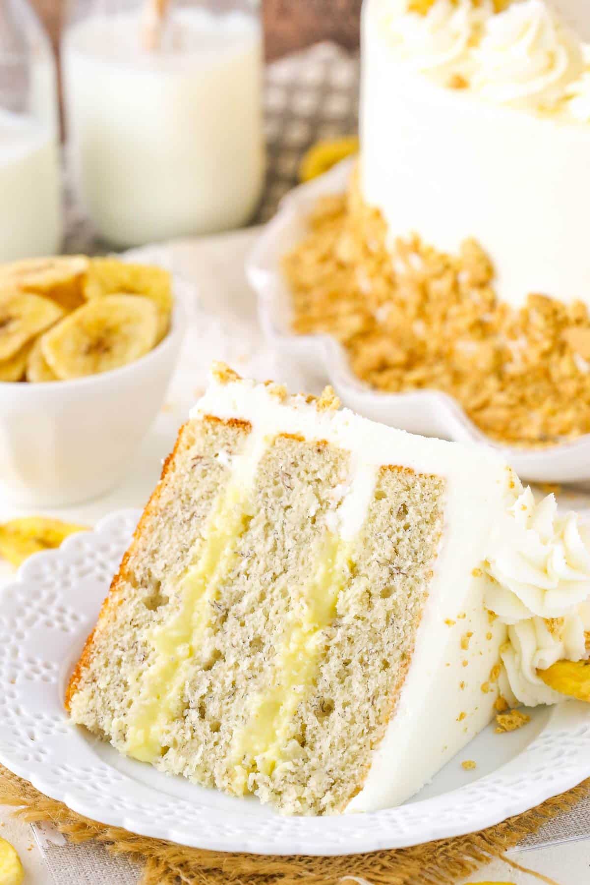 A slice of banana cream layer cake on a small white plate.