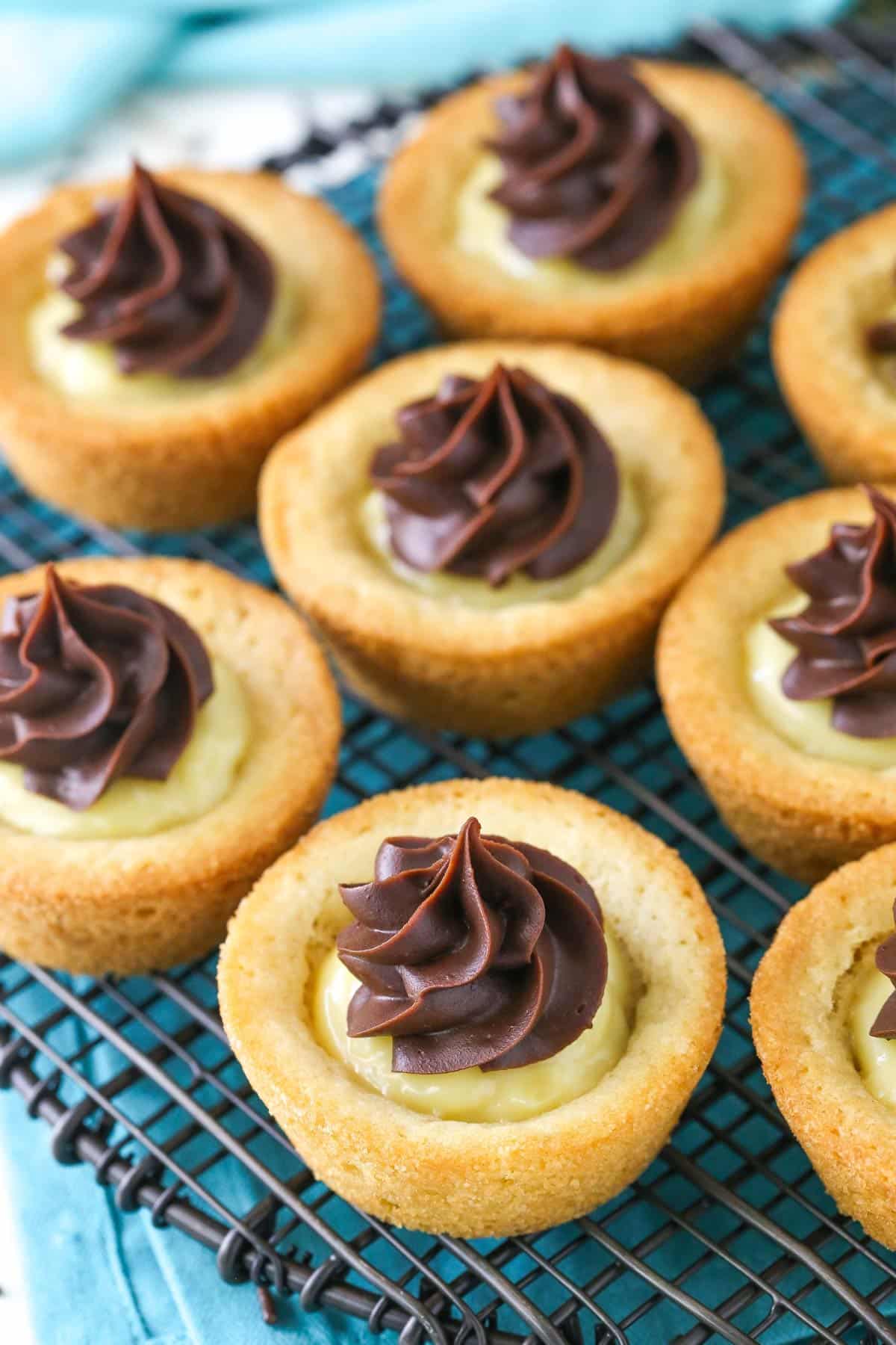 Top view of boston cream pie cookie cups on a wire rack.