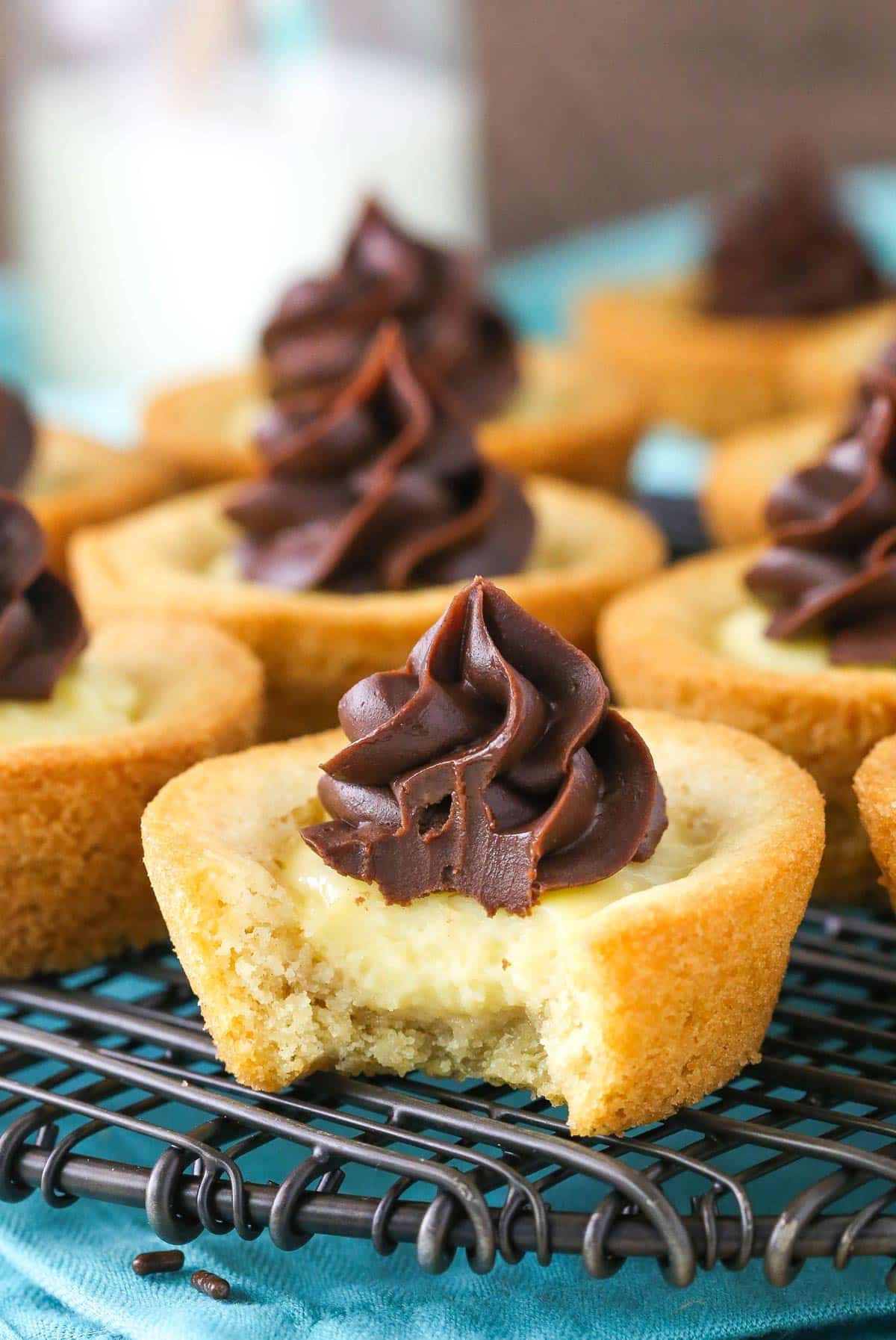 A boston cream pie cookie cup with a bite taken out of it.