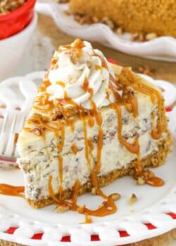 A slice of browned butter pecan cheesecake drizzled with caramel sauce.