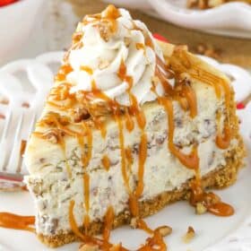 A slice of browned butter pecan cheesecake drizzled with caramel sauce.