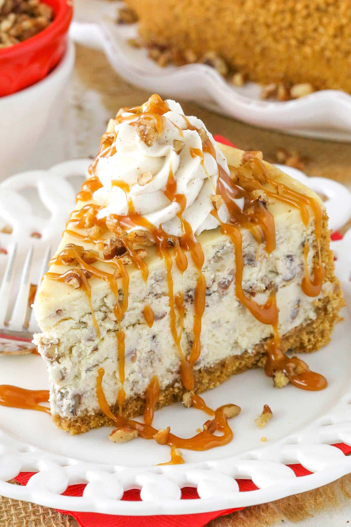 A slice of browned butter pecan cheesecake drizzled with caramel sauce.
