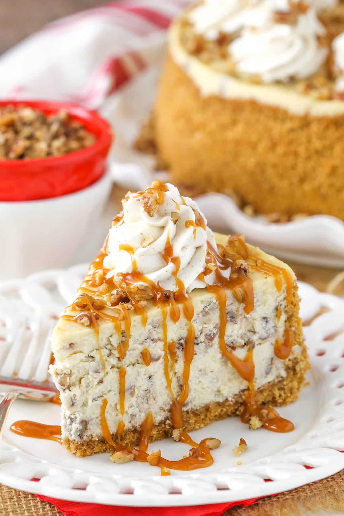A slice of browned butter pecan cheesecake on a small white plate.