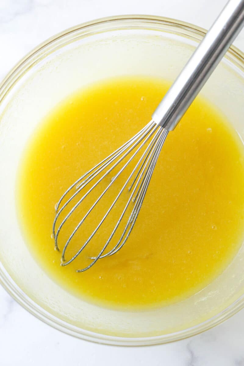 These moist, chewy Brownie Bites are so easy to make and WAY better than the ones you can get at the store. Try to eat just one. I dare you. Whisking eggs into butter, oil, sugar, and vanilla.