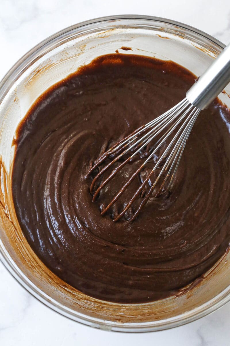 These moist, chewy Brownie Bites are so easy to make and WAY better than the ones you can get at the store. Try to eat just one. I dare you. Combining the wet and dry ingredients fo brownie batter.