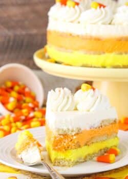 A slice of candy corn icebox cake with a bite removed.