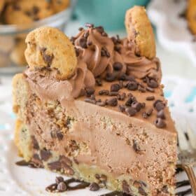 A slice chocolate chip cookie crust cheesecake on a white plate.