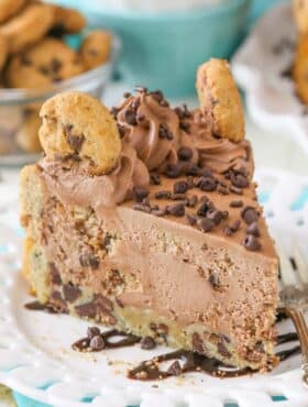 A slice chocolate chip cookie crust cheesecake on a white plate.
