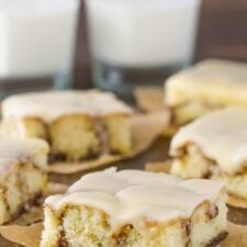 Close up of a slice of cinnamon roll cake on a piece of parchment paper.