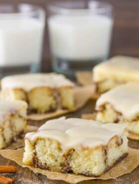 Close up of a slice of cinnamon roll snack cake on a piece of parchment paper.
