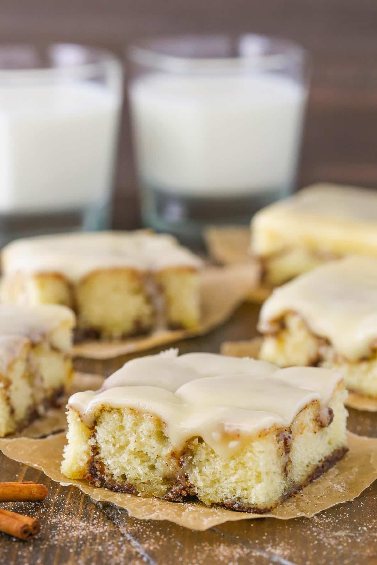 Close up of a slice of cinnamon roll snack cake on a piece of parchment paper.