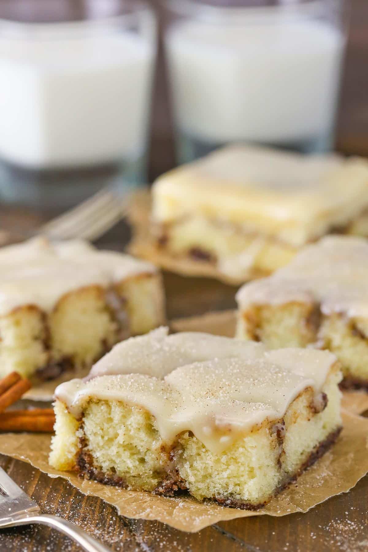 A few slices of cinnamon roll snack cake on parchment squares.