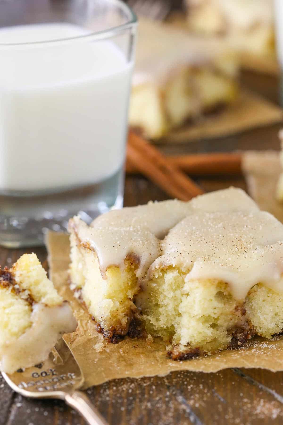 A slice of cinnamon roll snack cake with a bite removed.