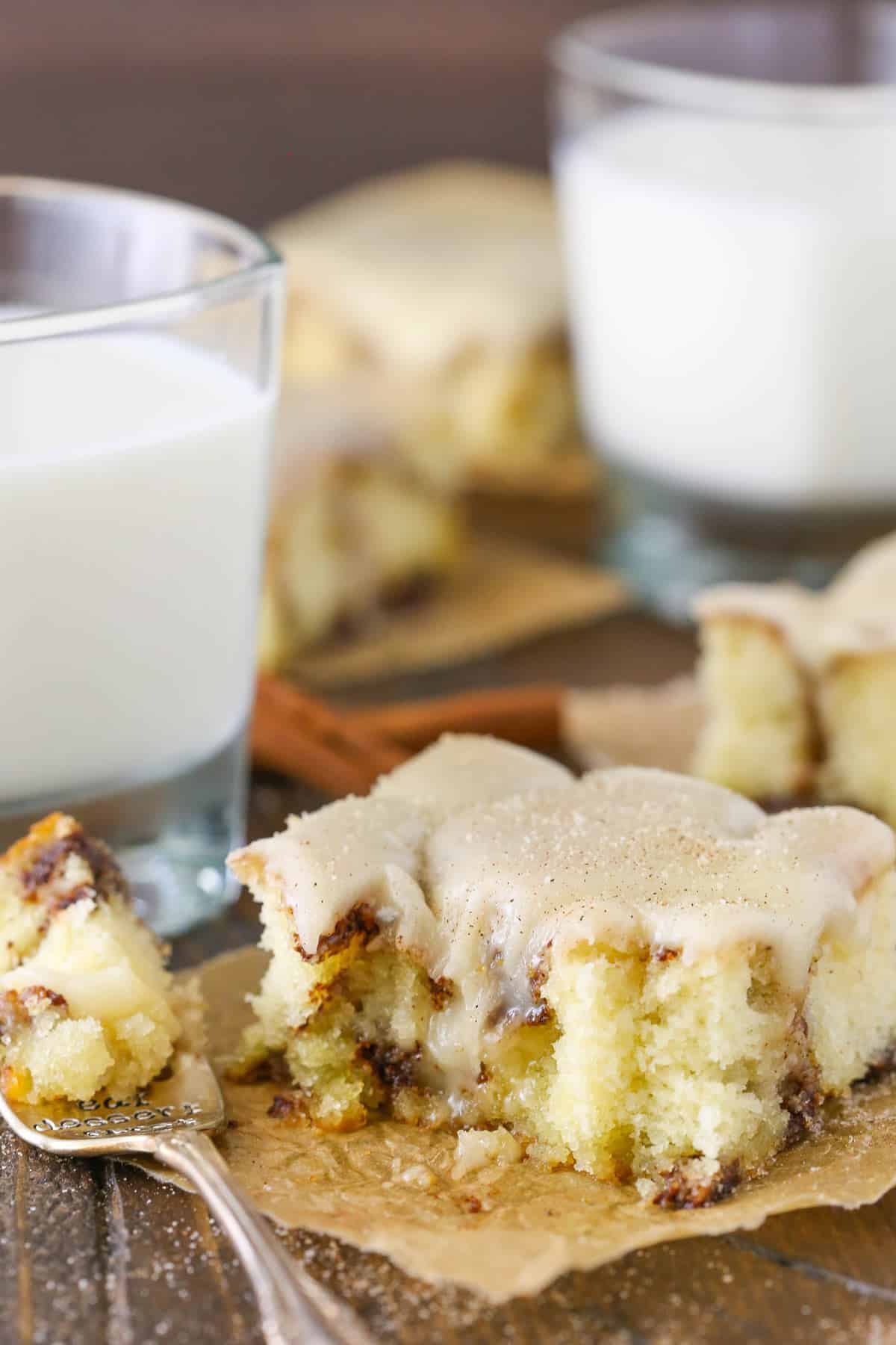 A slice of cinnamon roll snack cake with bites missing.