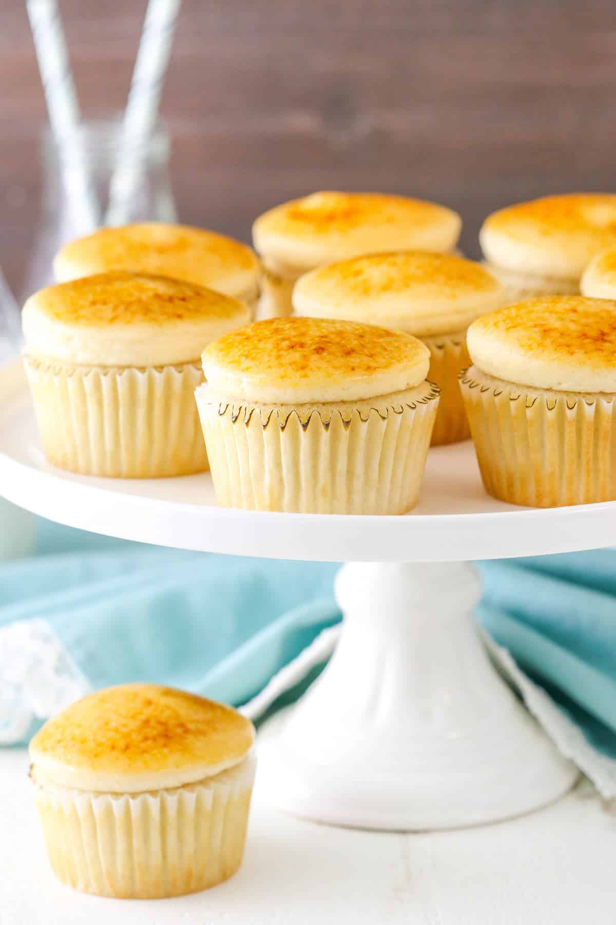 A cake plate with creme brulee cupcakes on it and one below.