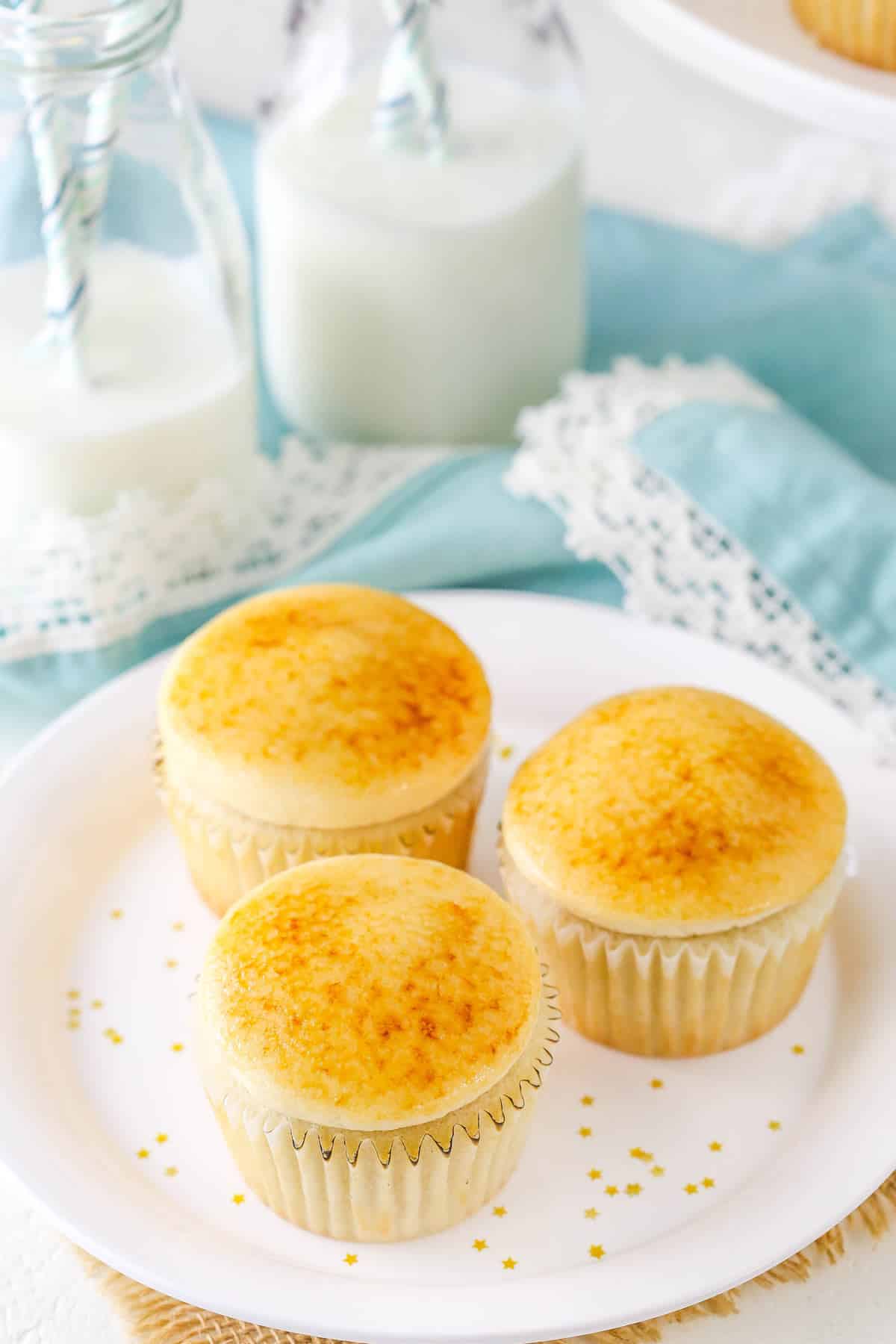 Three creme brulee cupcakes on a small white plate.