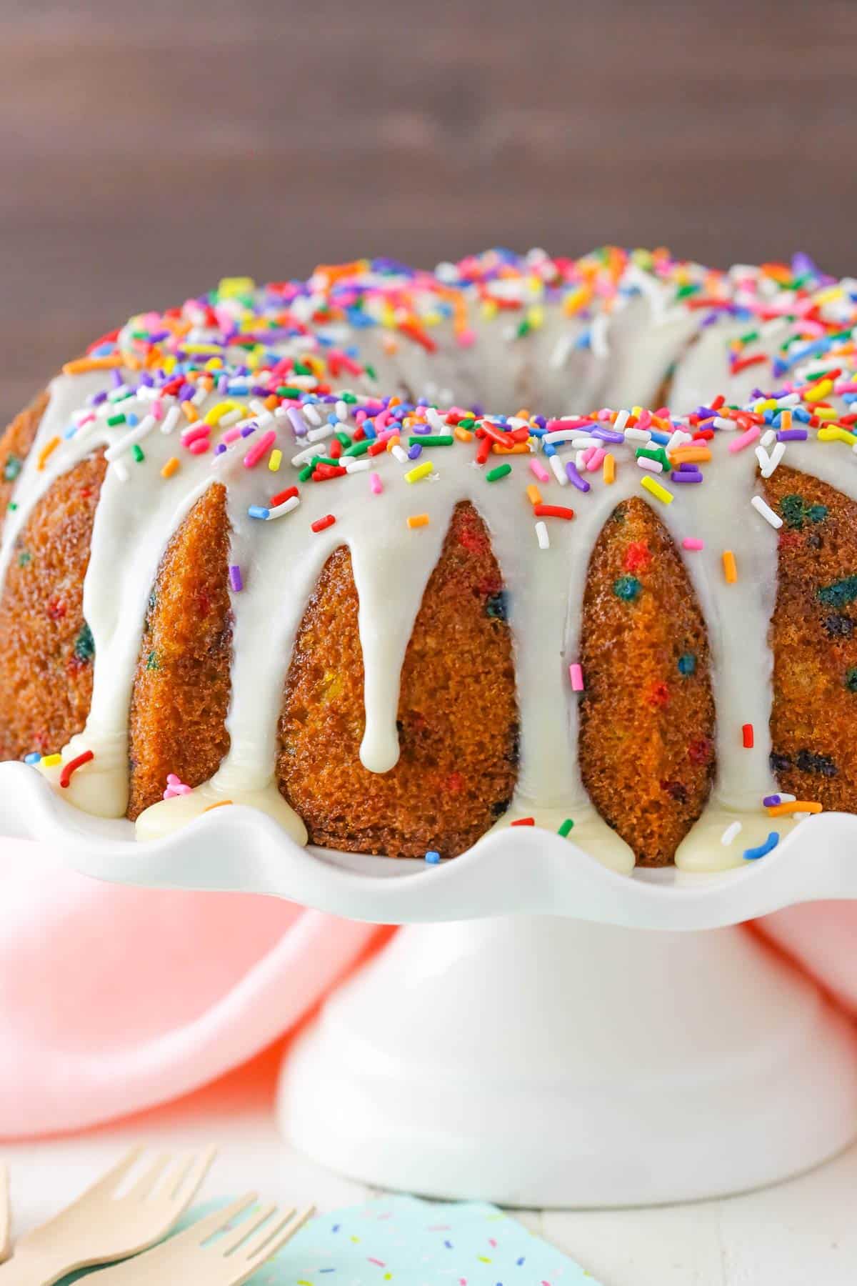 Close up of a funfetti bundt cake on a white cake stand.