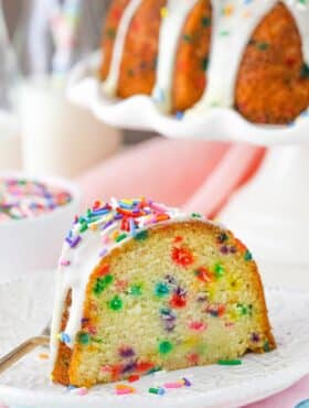 A slice of funfetti bundt cake on a white plate.